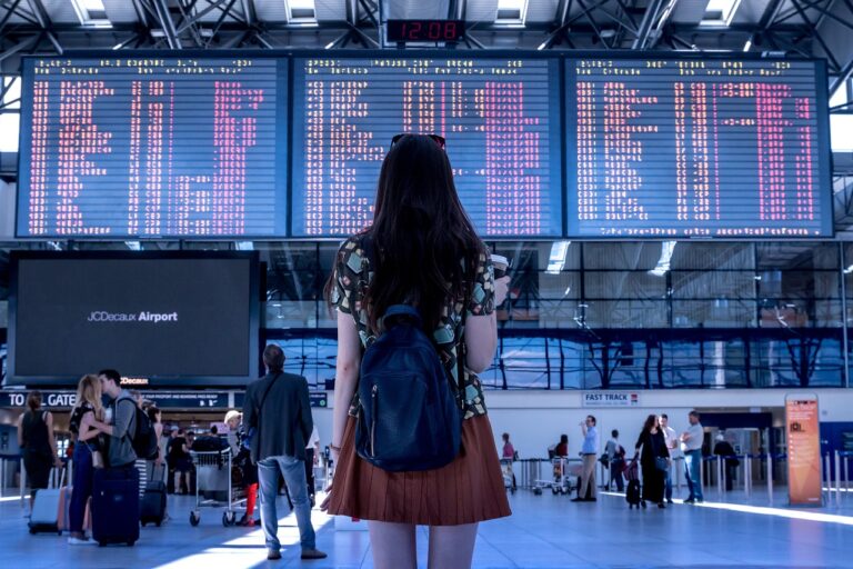 turista delante de un panel de CRM de viajes en un aeropuerto.